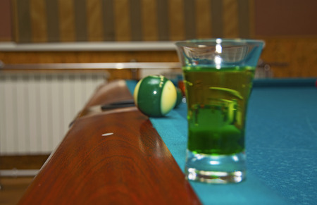 on a billiard table stand with coloured glasses of alcohol. Billiards, balls and stackの写真素材