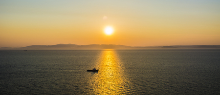 a ray of sunset, the sea floats a vessel sailing on the Gaza exactly a flare of the Sun. a beautiful sunsetの写真素材