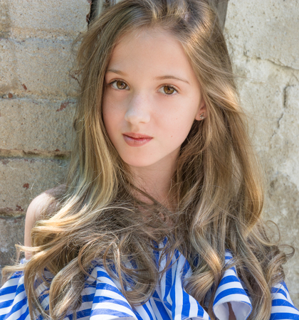a young girl is sitting in the window opening, in the devastated building in the Park, portrait of a young beautiesの写真素材