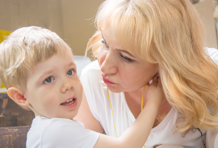 Granny grandson, both blonde kisses, cuddling and kissing. indoorsの写真素材