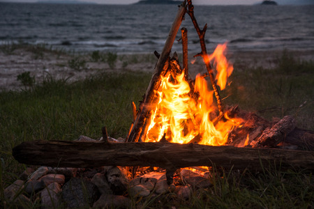 fire burning on the beach at night. bright fire, firewood. flame overnightの写真素材