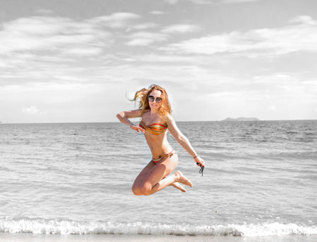 beautiful girl in bikini posing on a deserted beach. white sand, turquoise sea and a young girl. with a sunny dayの写真素材