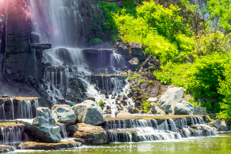 beautiful waterfall under sunlight, many beautiful water jets surrounded by green forests. travelの写真素材