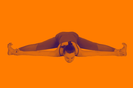 young girl performs different poses of yoga, flexible beautiful model on a white background. meditation and asanas. the harmony of body and spiritの写真素材