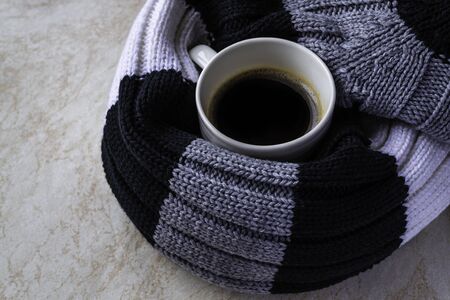 Cup of black coffee wrapped in a striped scarf. Concept of autumn and winter moon.の写真素材