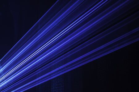 Abstract background with blurred ray of light. Lighting and spotlights lines, stage light and smoke. Disco laser with beams through smoke. Classic blue, trend color. Color of the yearの写真素材