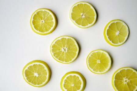 Lemon slices randomly lie on the light surface of the table. の写真素材