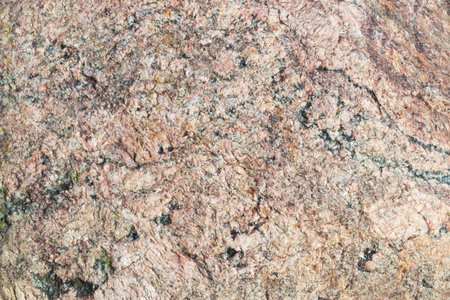 Natunal stone texture. Beige or pink granite surface with black splashes. 