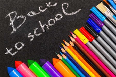 Inscription Back to school on chalk blackboard. And frame from pencils and felt-tip pens.の写真素材