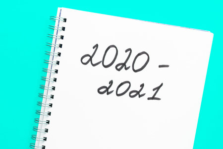 Back to school. The inscription 2020 - 2021 in a white notebook with a spiral, on a blue background....
