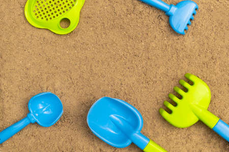Sandbox. Summer concept. Children's sand toys outdoors. Background with colored shovel, rake, sieve and bucket.の写真素材