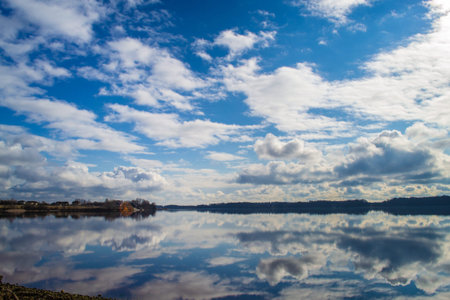 Scenic view of the river Daugava in the evening. Latvia nature. Beautiful clouds on blue sky and...