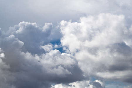 A small piece of blue sky shines through the clouds. Gray white clouds.の写真素材