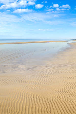 Dzintari Beach, Jurmala, Latvia. Sunny day. Wavy sand on the beach, sea and blue sky with clouds.の写真素材