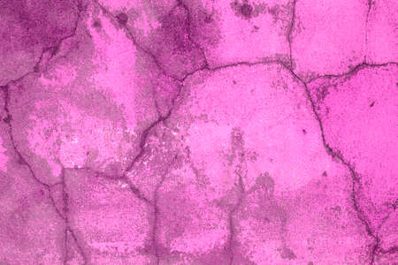 Pink old concrete wall with many long cracks. Urban style. Copy space. Cracked texture, abstract background.の写真素材