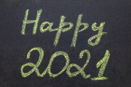 Chalkboard with yellow chalk handwritten inscription Happy 2021. Flat lay, layout. New year concept.の写真素材