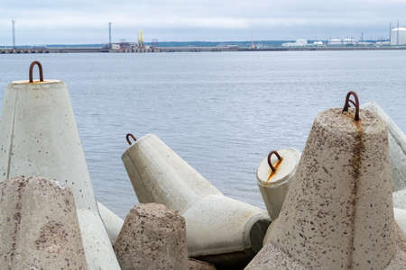 The Venta River flows into the Baltic Sea. Breakwater concrete dam. Tetrapods in sea water. Pier protect coastal structures from storm sea waves. Ventspil, Latviaの写真素材
