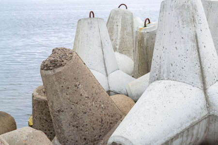 Tetrapods in Baltic sea water. Breakwater concrete dam Venta river. Pier protect coastal structures from storm sea waves. Ventspil, Latviaの写真素材