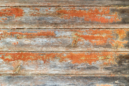 Aged dilapidated wall. Brown or red orange boards. Old, cracked and peeled paint. Rustic background. Place for text, copy space.