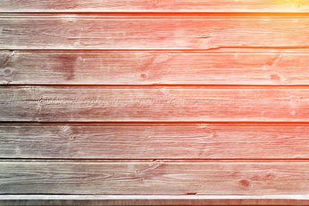 The sun rays fall on the old fence. Rustic background. Wooden wall of an old house. Horizontal gray boards close up. Place for text, copy space.の写真素材