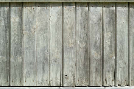 Old vertical wooden planks close up. Gray white wall of planks. Sunny day. Place for text, copy space, background, pattern.の写真素材