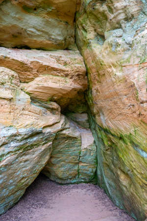 Interesting cave in Licu - Lange rock, Latvia. Fragment of sandstone cliff. In forest in sunny day.の写真素材