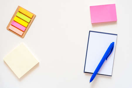 Stickers, notepad and pen on a light white background. Colored office school supplies frame. Flat lay with copy space.の写真素材