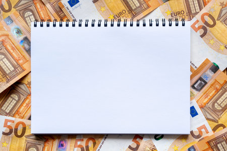 Banknotes and blank page of notebook. Background of money in denomination of 50 euros. Flat lay,...