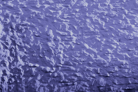 Bright blue - purple background, with grainy texture surface. Concrete very peri color painted wall...
