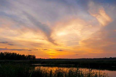 The Lielupe River at sunset. Latvia. Bright, colorful sky, orange, yellow, golden colors of clouds.の写真素材