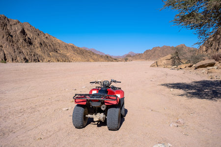 ATVs and mountains landscape on background. Sharm el Sheikh, Sinai peninsula. Quadricycle safari park in Egypt sand desert. Extreme travel on all-terrain vehicle.の写真素材