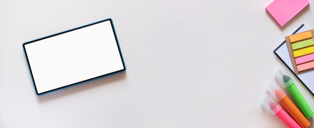 Colorful stationery, stickers, markers on the side and tablet with copy space, mockup on another...
