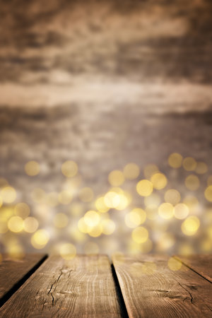 Wood surface and defocused bokeh gold lights at background. Empty rustic wooden table with blurred Christmas lights. New year mood.の写真素材