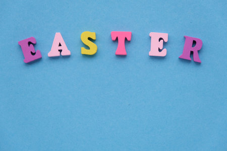 The inscription Easter from wooden colored letters on a light blue background. Flat lay, copy spaceの写真素材