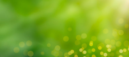Abstract green background with defocus lights and sun rays and glare. Copy space, banner. Summer or spring mood.の写真素材