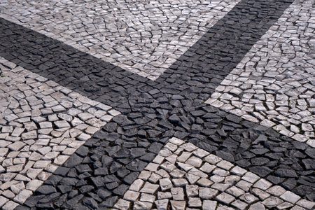 Portuguese traditional black and white pavement made from calcada tiling. Fragment of sidewalk paving in Funchal, Madeira islandの写真素材