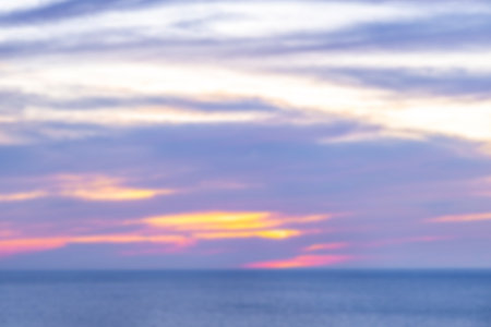 Blurred sunset over the sea. Beautiful vibrant clouds, purple, pink and yellow colors. Copy space. Summer time and mood.の写真素材
