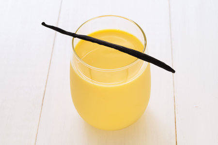 Vanilla milk in glass with vanilla pod, selective focus, horizontal