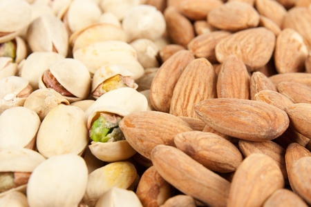 Fresh salted almonds and pistachios background.の写真素材
