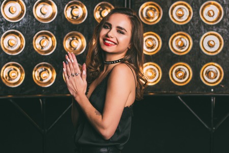 Young woman studio fashion portrait. Dark golden colors. Beautiful sexy woman on black backgroundの写真素材