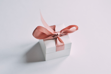 Close up shot a small gift wrapped with pink ribbonの写真素材