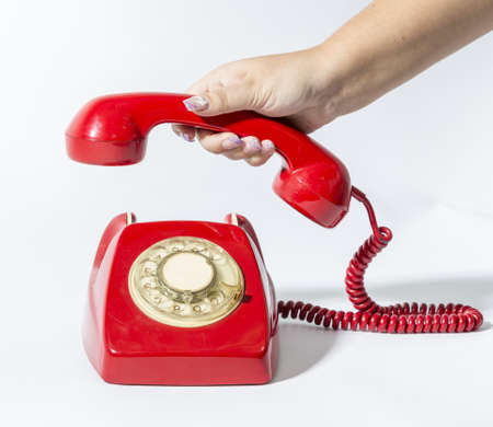 a hand is picking a red phone oldの写真素材