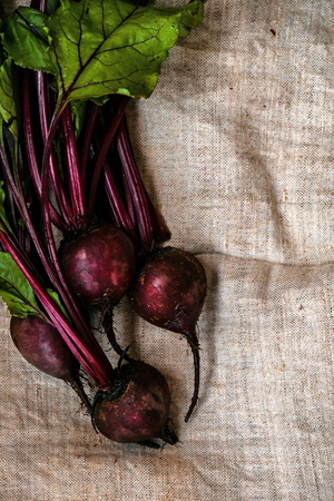 Bunch of fresh organic beetroots. Vertical free space linen background.の写真素材