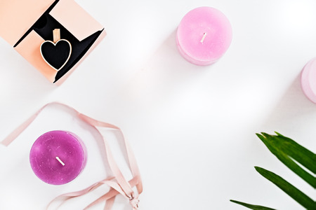 Pink scented candles and green leaves on white. Woman decorating ideas.の写真素材
