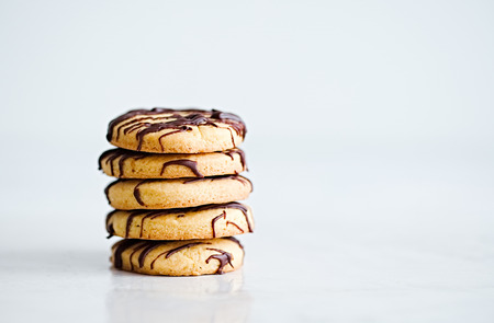 Stack of butter cookies with chocolate drizzle isolated on on a white background. Copyspace for text.の写真素材