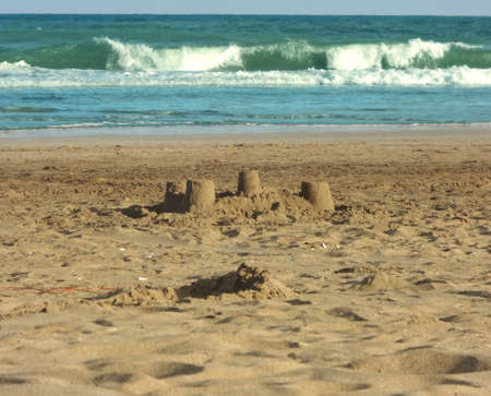 Sand castle by the sea on the beachの写真素材