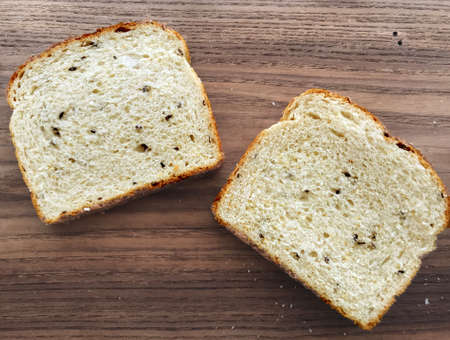 Close-up of sliced bread with seeds on wooden boardの写真素材