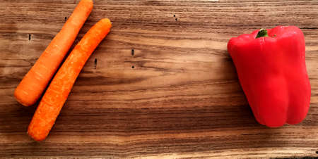 Background for recipes of Carrots and red pepper on wooden boardの写真素材