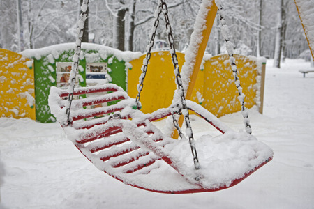 bench swing on playground in winterの写真素材