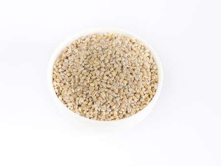 Barley in ceramic bowl on white backgroundの写真素材